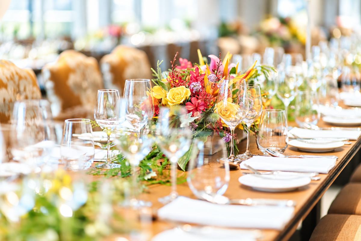 Une longue table de mariage avec des fleurs éclatantes